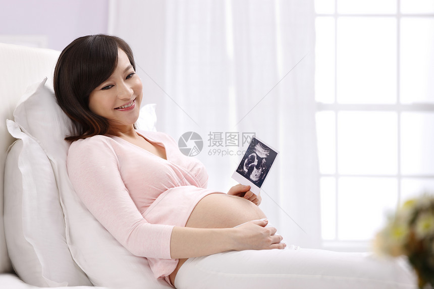 20多岁窗帘青年人孕妇拿着超声波照片图片