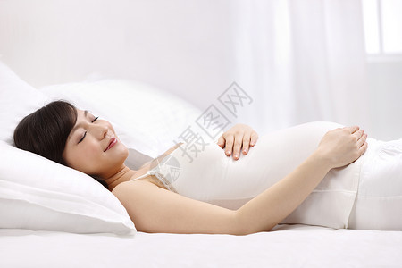 半身像快乐自信孕妇躺在床上睡觉背景图片