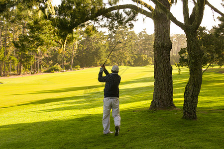 高尔夫球场上打球的男性高清图片