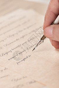 英文签名男人的手拿着鹅毛笔在写字背景