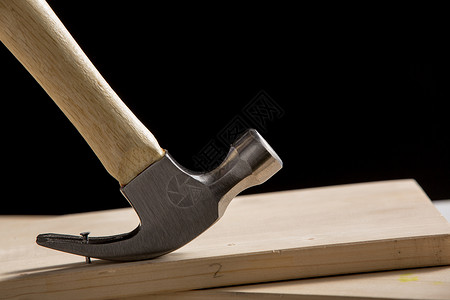 木头制品锤子与厚木板背景