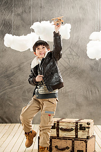 灰色木质边框高举玩具飞机的快乐男孩背景