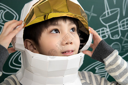 插画手戴着航天员头盔的小男孩站在黑板前背景