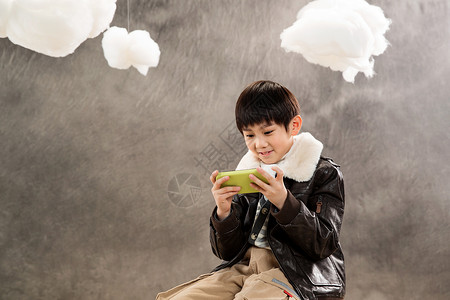庆六一棉花糖小男孩坐着玩游戏机背景