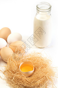 奶制品玻璃瓶牛奶和鸡窝里的鸡蛋高清图片