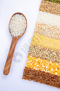 盛满大米的木匙和五谷杂粮图片