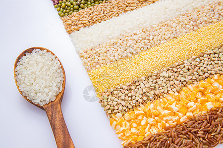绿色食品稻谷五谷杂粮平铺和盛满大米的木匙高清图片