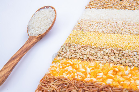 盛满大米的木匙和五谷杂粮图片