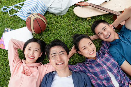 快乐的四个大学生躺在草地上图片