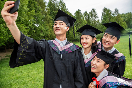 表情连拍四个身穿学士服的大学生一起自拍背景