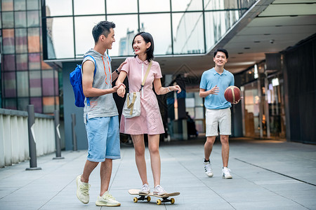 帅气的大学生教女朋友滑滑板背景图片