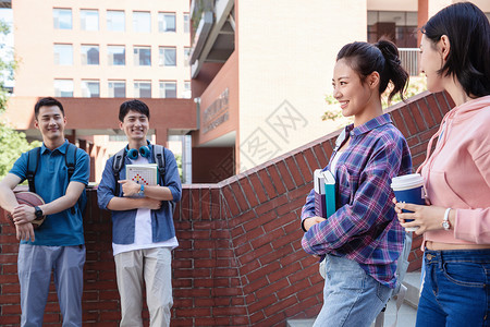 四个人刚下课的大学生在校园里图片