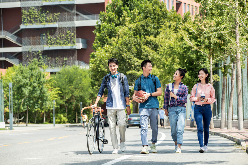 阳光下快乐的大学生在校园里步行图片