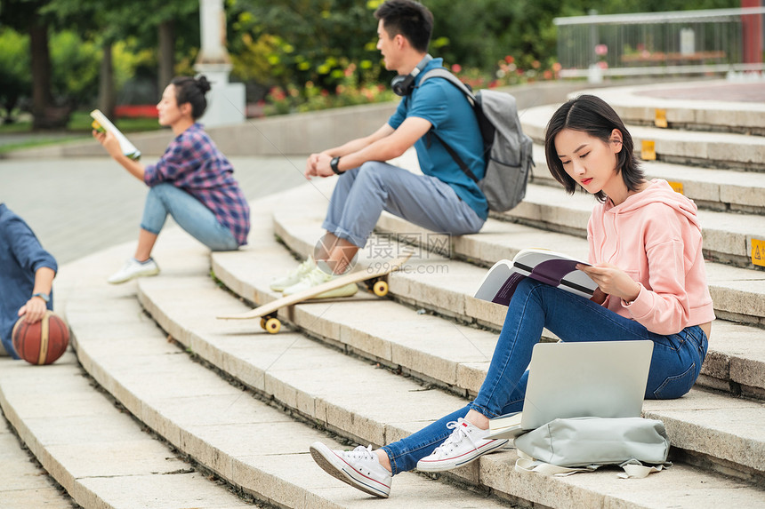 休闲活动休闲装教科书快乐的大学生坐在台阶上学习图片