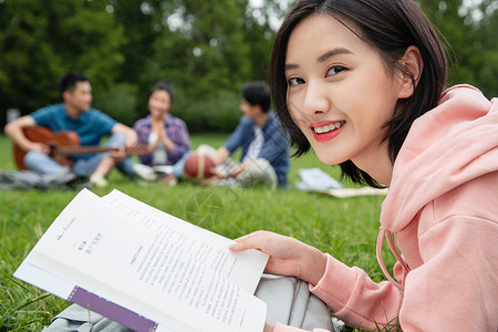 沟通前景对焦草坪大学生在草地上享受课余时间图片