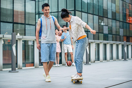 帅气的大学生教女朋友滑滑板图片