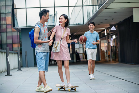 帅气的大学生教女朋友滑滑板高清图片