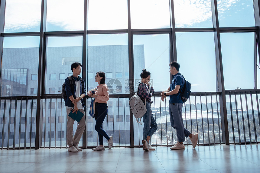 沟通欢乐交流教学楼里大学生靠在窗户前聊天图片