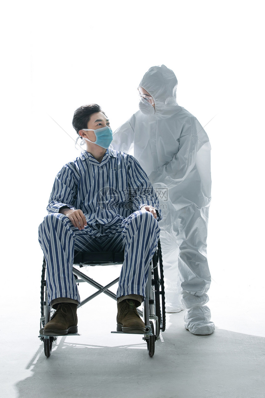医务工作者推着坐轮椅的患者图片