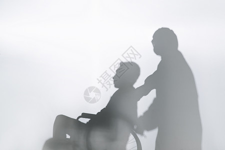 医务工作者推着坐轮椅的患者剪影高清图片