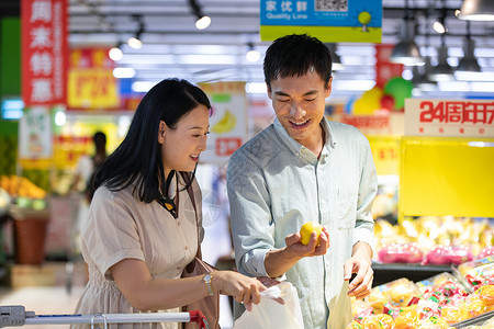 甜甜圈促销中年夫妇在超市挑选水果背景