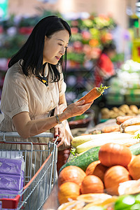 中年女在超市挑选蔬菜高清图片