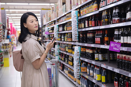 葡萄酒促销主图中年女在超市购物背景