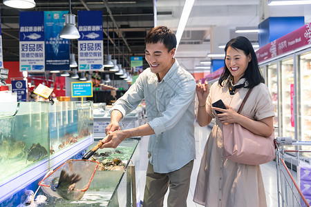 网商银行中年夫妇在超市买鱼背景