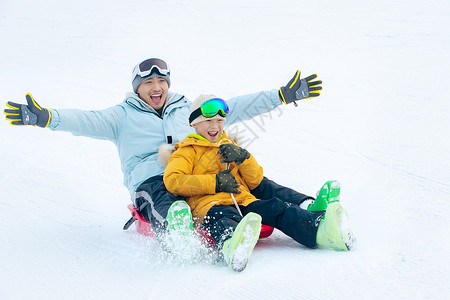 小孩大喊活力快乐父子坐着雪上滑板滑雪背景