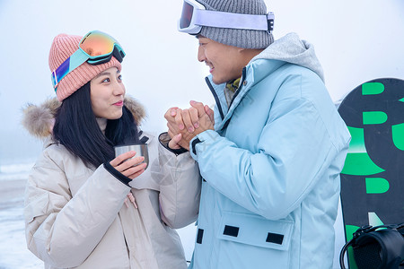 带帽子的情侣带儿子女儿冬日滑雪的父母背景