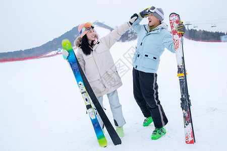 带帽子的情侣带儿子女儿冬日滑雪的父母背景