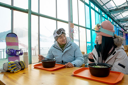 餐厅午餐活动减压冬天帽子滑雪完的青年伴侣在餐厅用餐背景