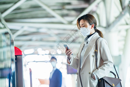 疫情交通戴口罩的年轻女人站在地铁站台上图片