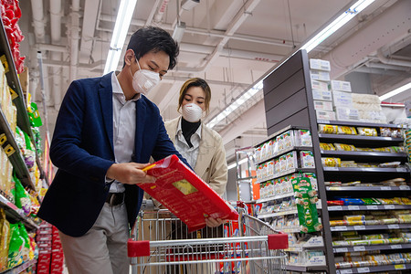 食品污染疫情生活青年夫妇戴口罩在超市购物背景