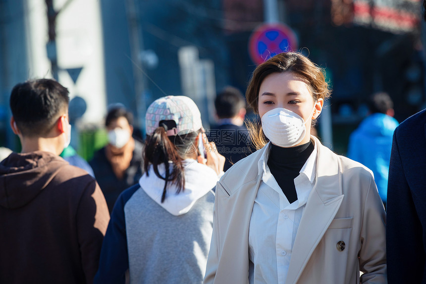 青年女人戴口罩在户外行走图片