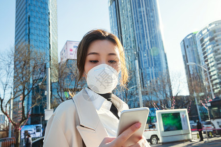 白领戴口罩的青年女人看手机图片