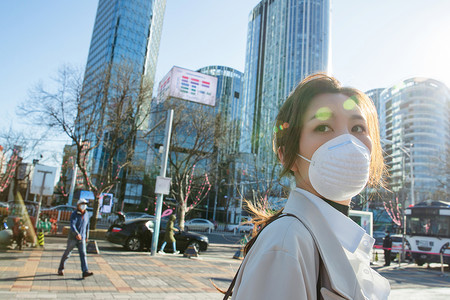 城市青年女人戴口罩在户外行走图片