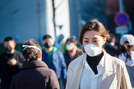城市空气污染青年女人戴口罩在户外行走背景