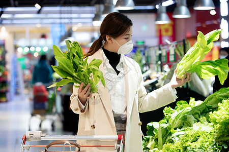 婚嫁用品促销消费戴口罩的青年女人在超市购买青菜背景