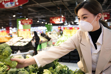 戴口罩的青年女人在超市购买蔬菜图片
