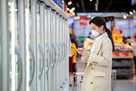 传染病戴口罩的青年女人在超市购物图片