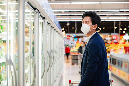 戴口罩的青年男人在超市购物图片