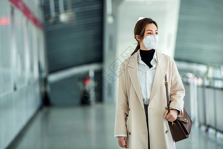通勤者戴口罩的年轻女人走在地铁站里图片