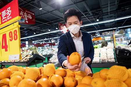 戴口罩的青年男人在超市购买水果图片