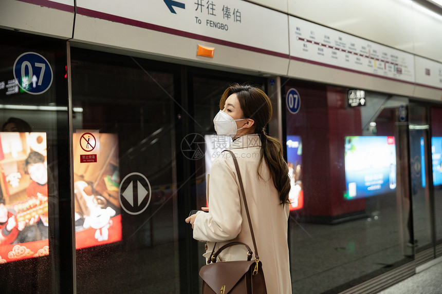 年轻女人站在地铁站台上图片