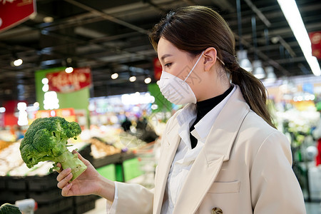 疫情生活戴口罩的青年女人在超市购买蔬菜图片