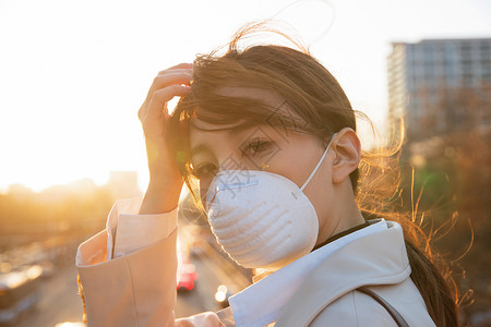 通勤者青年女人戴口罩在户外行走图片