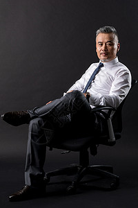 坐在椅子上的成功商务男士图片
