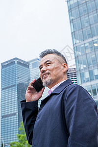 笑中间商务男士站着楼群中间打电话背景