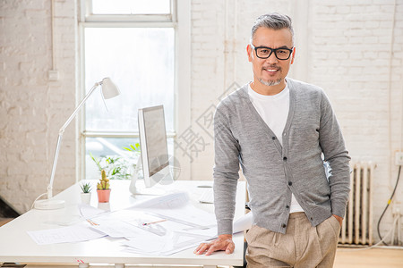 充插两用台灯在室内研究图纸的中老年设计师男士背景